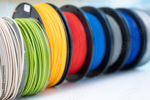 ABS and PLA filament next to 3D Printer. Plastic coils