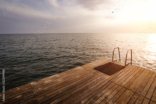 Summer photo of wooden pier and sunset time 