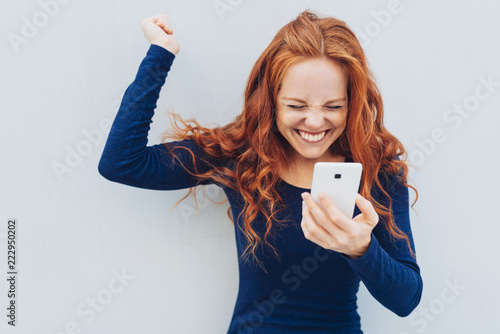 Young redhead celebrating good news photo