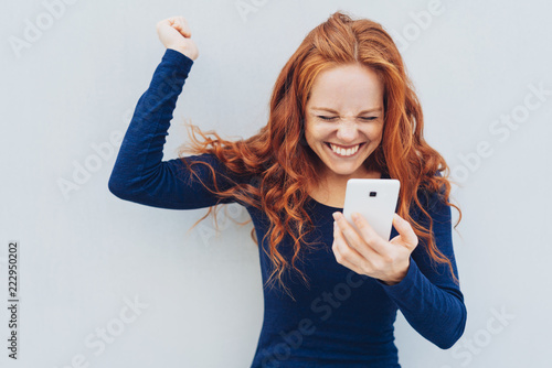 Foto Young redhead celebrating good news