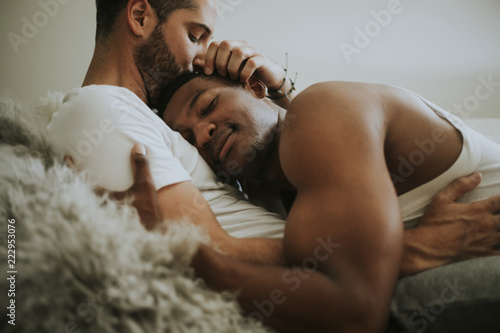 Gay couple cuddling in bed photo