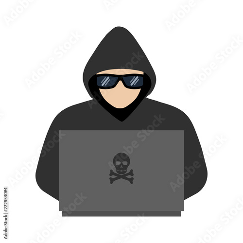 A man in a hoodie with a hood and glasses looks at the computer 