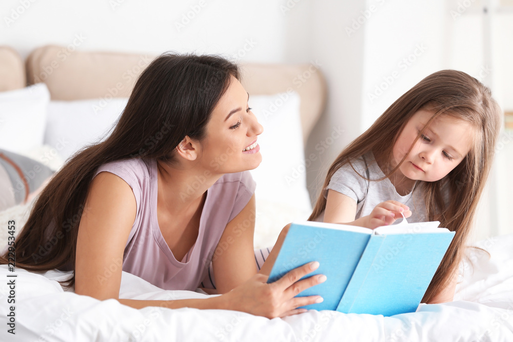 Mother and her daughter reading book together at home Mother and her daughter reading book together at home