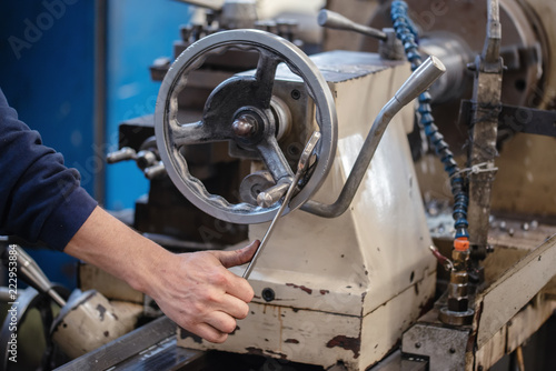 Craftsman turning valve of machine in factory