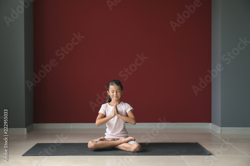 Little girl practicing yoga indoors © Pixel-Shot