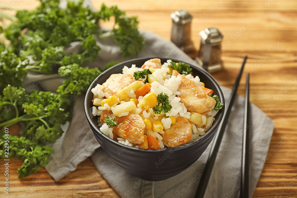 Bowl with boiled rice, meat and vegetables on wooden table Bowl with boiled rice, meat and vegetables on wooden table