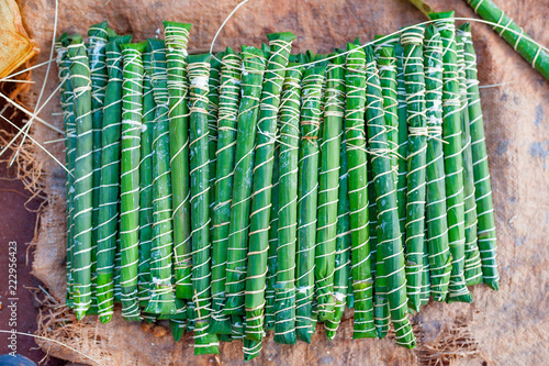 traditional cameroonian bâton de manioc made of manioca wrapped in plantain leaves on ground in african village photo