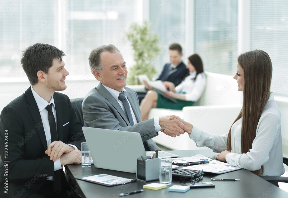 business woman shaking hands with an adult business partner. business woman shaking hands with an adult business partner.