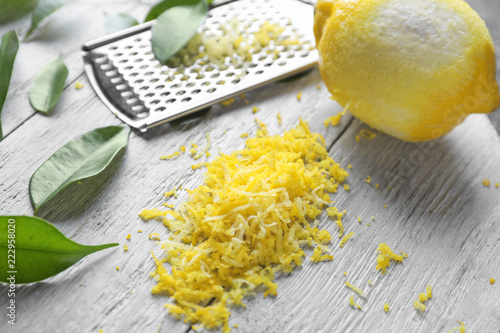 Peeled ripe lemon with zest on wooden background photo