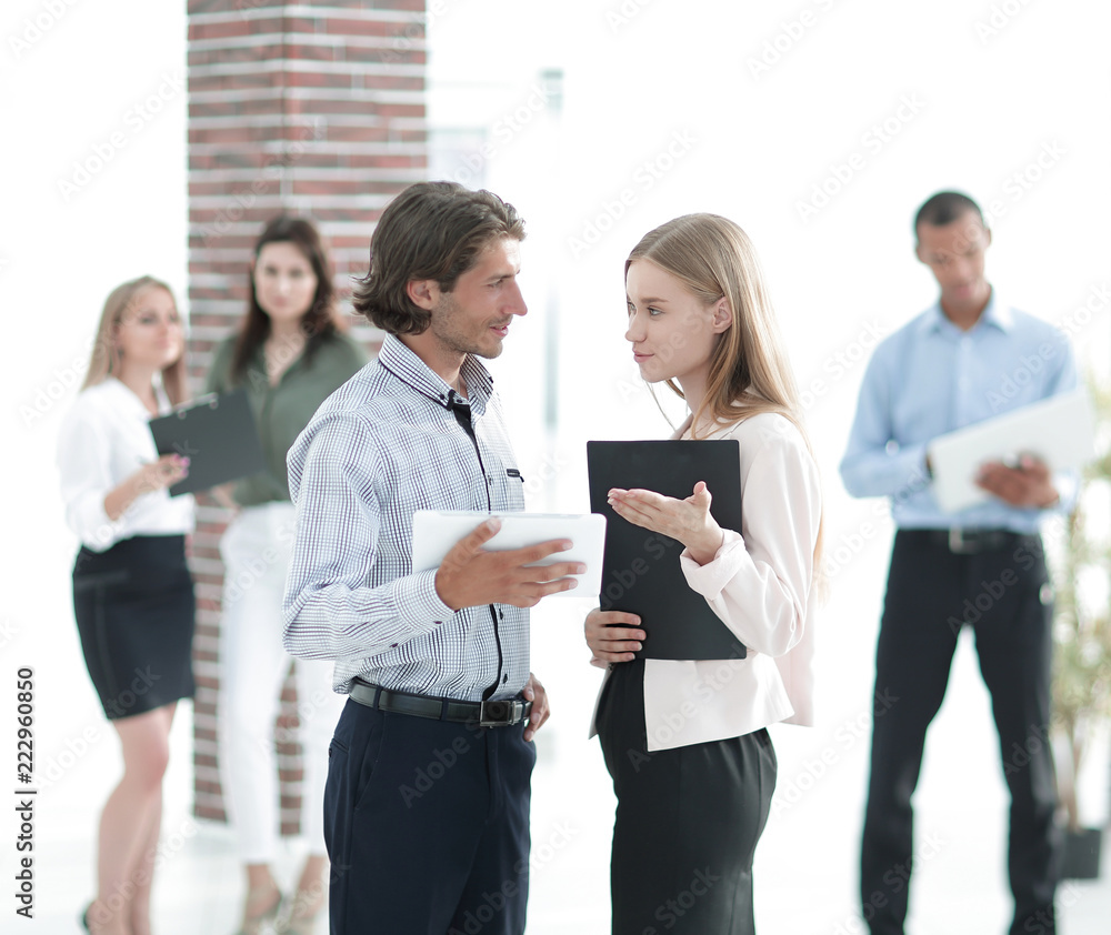 business colleagues talking, standing in a modern office business colleagues talking, standing in a modern office