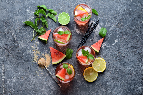 Glasses of tasty cold watermelon lemonade on dark table