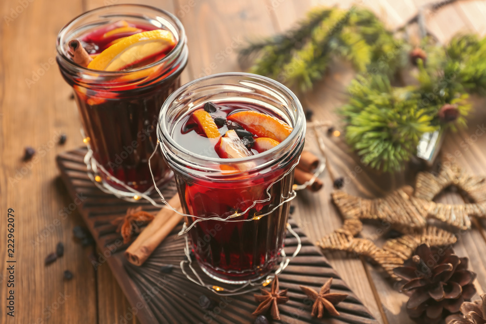 Jars of delicious mulled wine on wooden board Jars of delicious mulled wine on wooden board