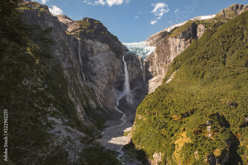 Queulat hanging glacier with falling ice into the smaller waterfall
