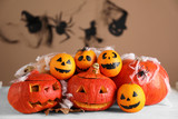Halloween pumpkins with creative oranges on light wooden table