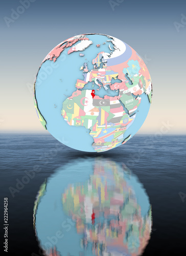 Fototapeta Naklejka Na Ścianę i Meble -  Tunisia on globe with flags above water surface
