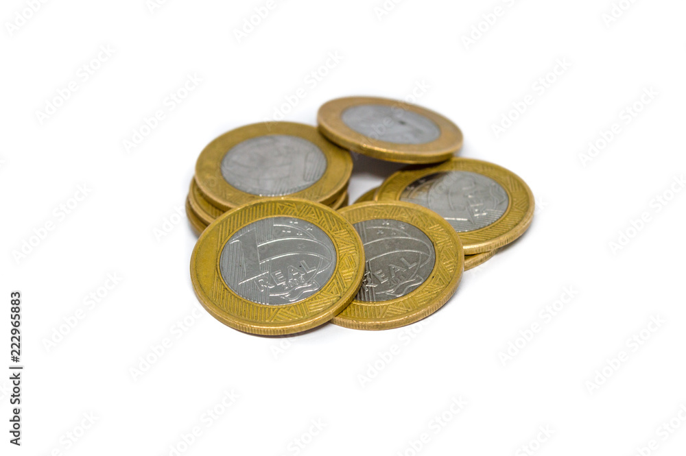 pile of Brazilian currency coins, in the present value of 1 one real, isolated on white background