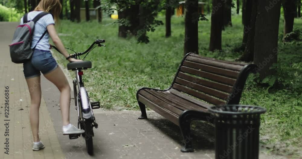 A young woman rides a bicycle and stops. A young woman rides a bicycle and stops.