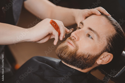 Man hipster having barber shave the barbershop.