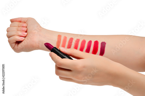 Lipstick swatches on woman hand isolated on white background.