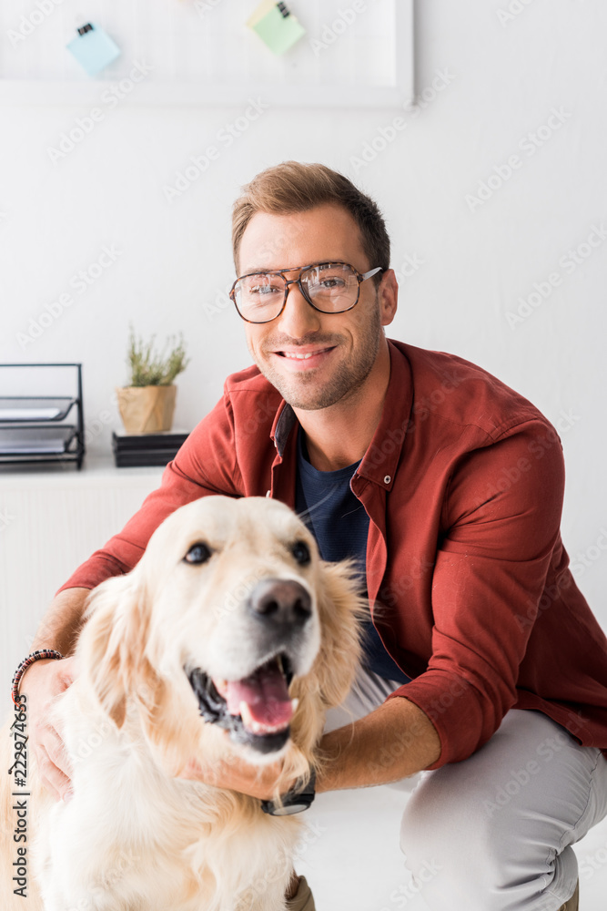 man in glasses hugging golden retriever and looking at camera man in glasses hugging golden retriever and looking at camera