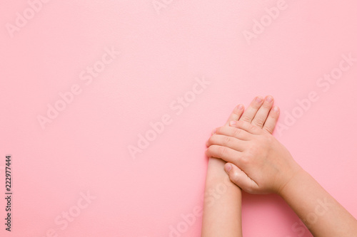 Little child s hands on pastel pink table. Care about clean  groomed kids body skin. Mockup for positive idea. Empty place for emotional  sentimental text  quote or sayings.