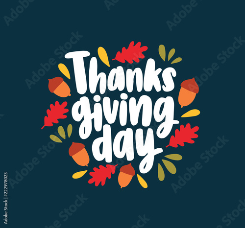Thanksgiving Day lettering written with elegant cursive calligraphic font and decorated by fallen autumn leaves and acorns