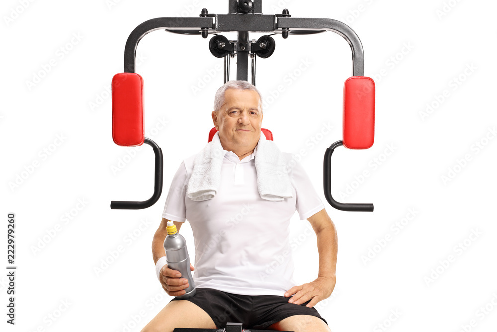Elderly man sitting on an exercise machine Elderly man sitting on an exercise machine