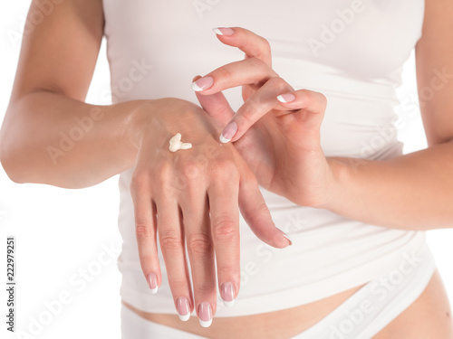 woman applying hand cream, white background, closeup