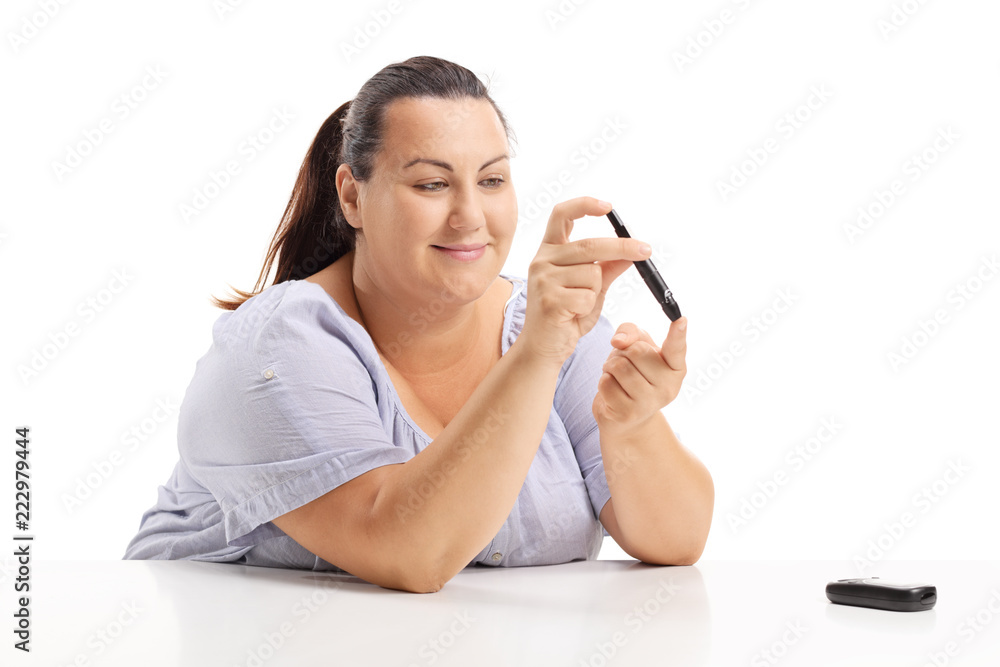 Overweight woman measuring her blood sugar level Overweight woman measuring her blood sugar level