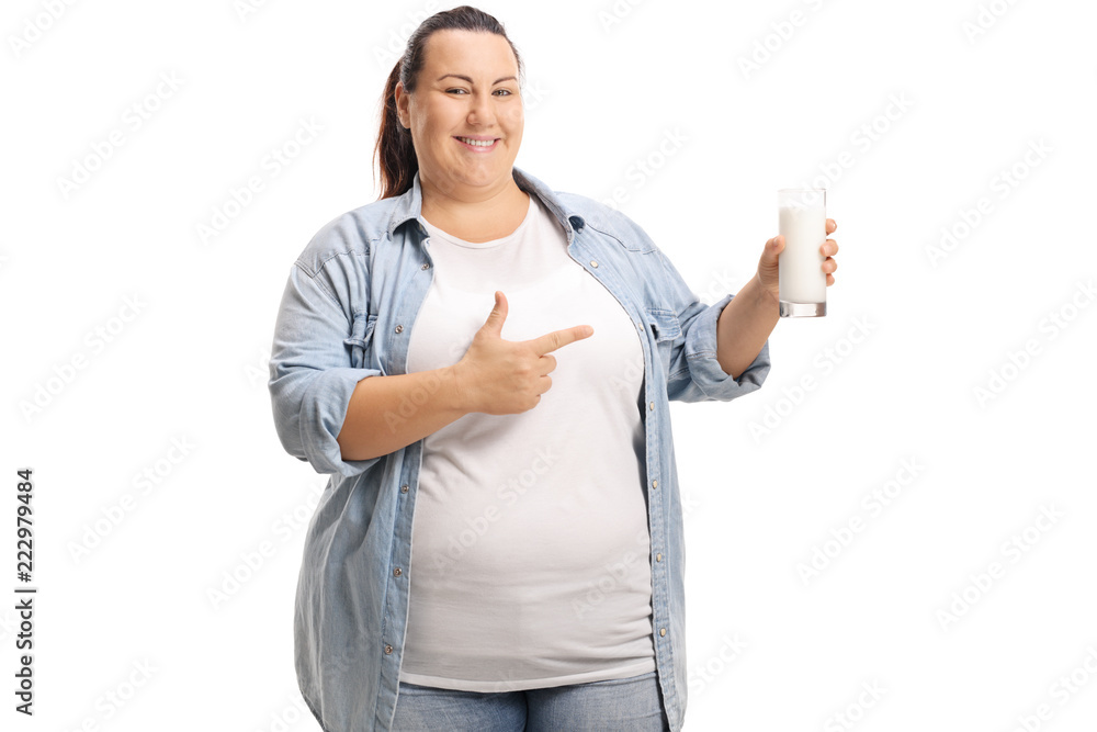 Overweight woman with a glass of milk pointing Overweight woman with a glass of milk pointing