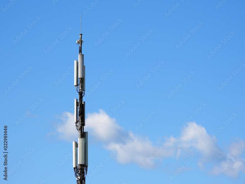 Cellular tower on the blue sky with some clouds background Cellular tower on the blue sky with some clouds background
