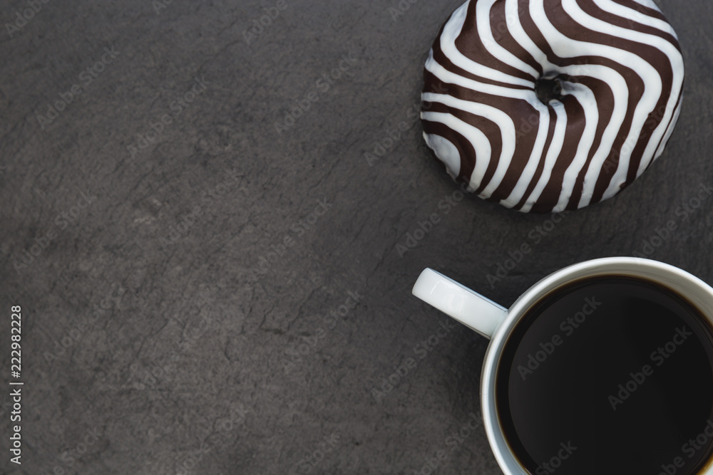Fotografie Striped donut and coffee cup dark background
