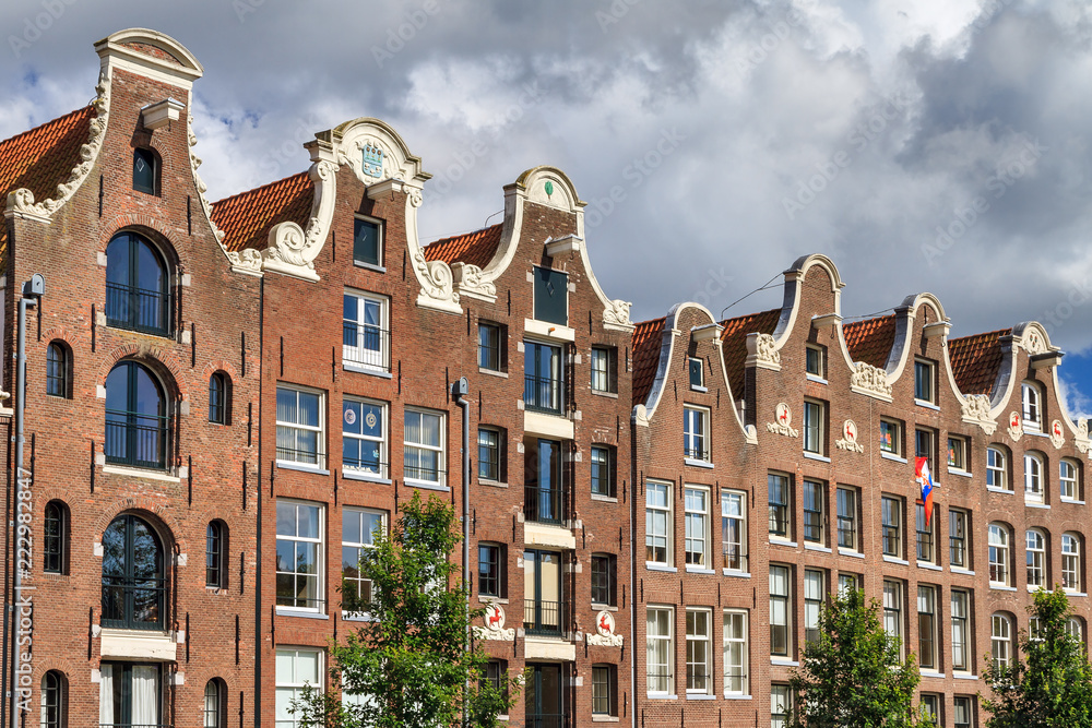 Beautiful view of the canal houses at the Prinsengracht canal in Amsterdam, the Netherlands, on a summer day with clouds
