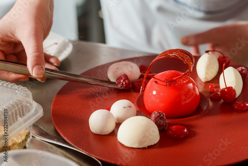 Fototapeta Naklejka Na Ścianę i Meble -  Decorating dessert with raspberries