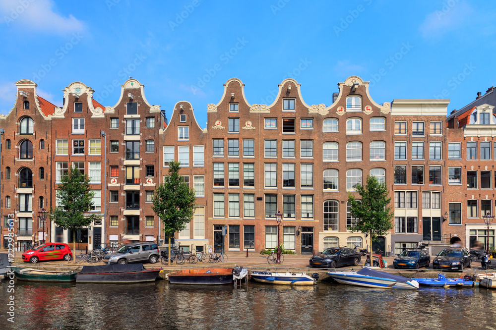 Beautiful view of the canal houses at the Prinsengracht canal in Amsterdam, the Netherlands, on a summer day with blue sky
