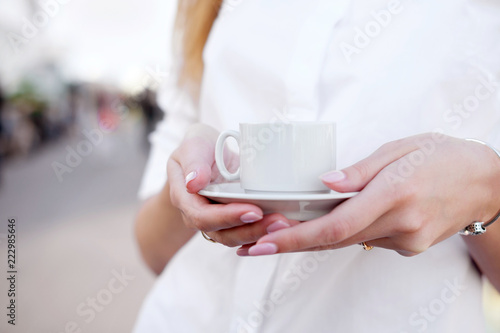 holding cup of coffee in the open air place or observation deck. Old town on background. Concept love morning.