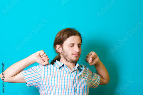 a young man stretches and yawns