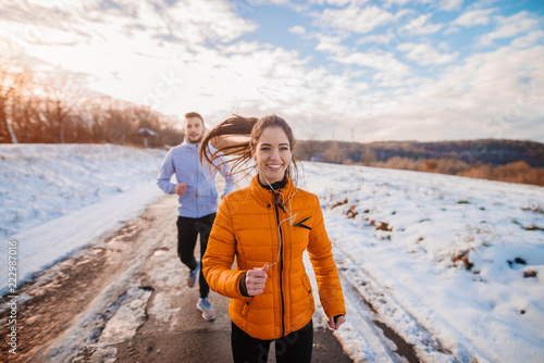 Fototapeta Naklejka Na Ścianę i Meble -  Fitness couple winter morning exercise at snowy mountain.