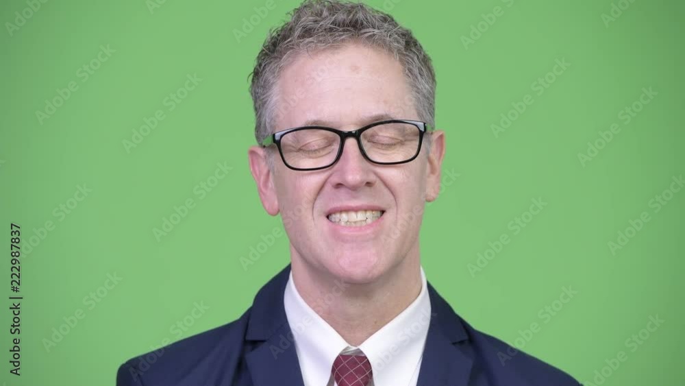 Studio shot of happy mature businessman relaxing with eyes closed Studio shot of happy mature businessman relaxing with eyes closed
