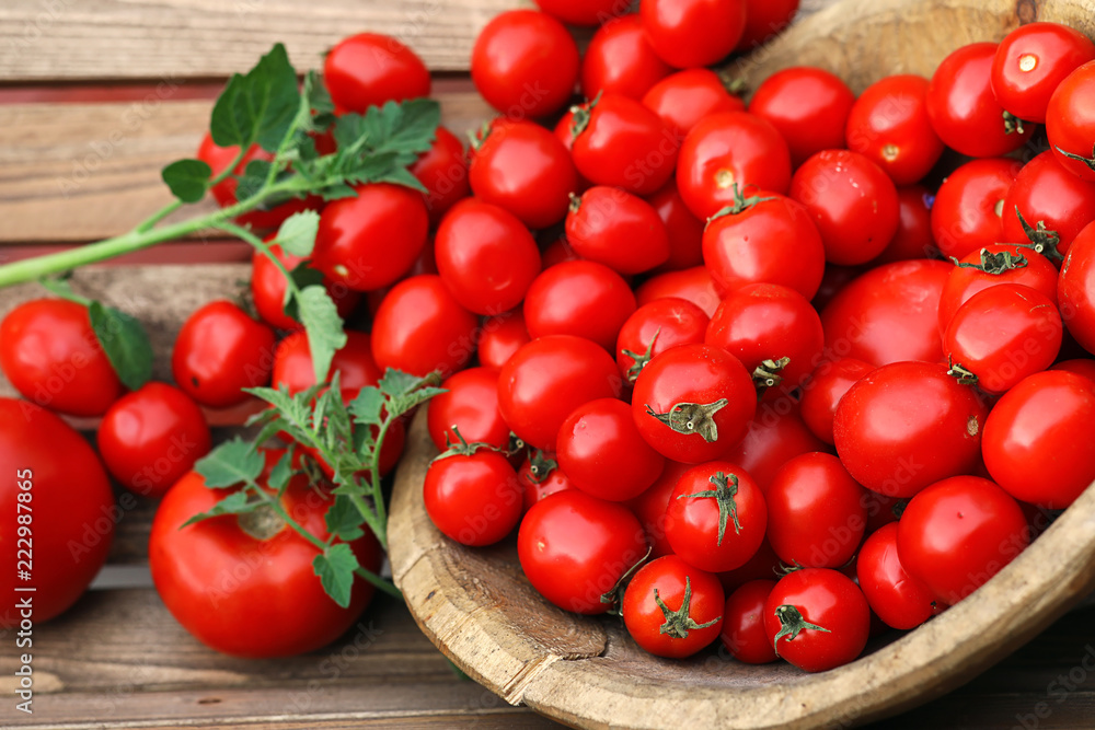 Fresh tomato crop in a wooden bowl Fresh tomato crop in a wooden bowl