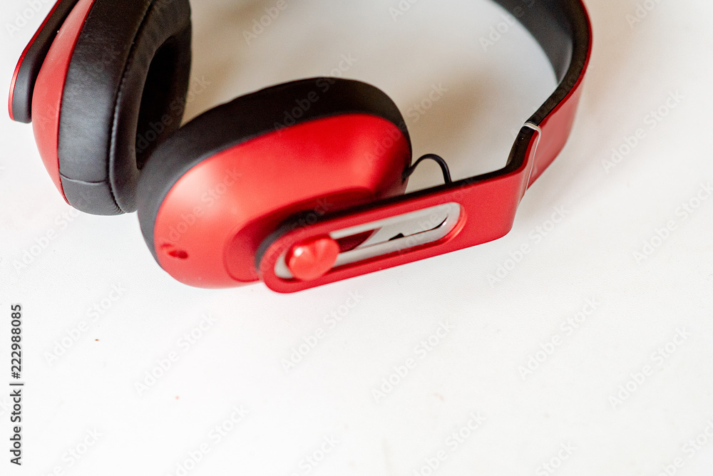Red headphones on a white-grey background. Photo with small noise and soft similar focus. Red headphones on a white-grey background. Photo with small noise and soft similar focus.