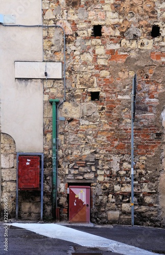 Remains of medieval wall with street name and old 