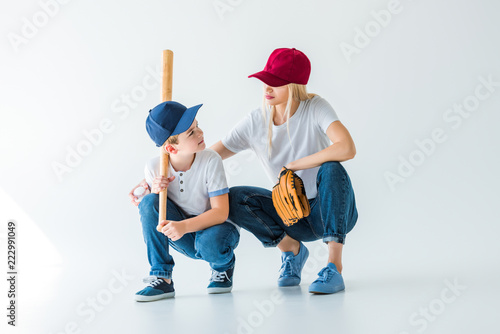 Photography mommy and son squatting with baseball bat and glove on white and looking at each