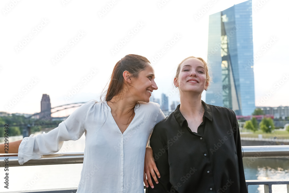 Girlfriends Standing on City Bridge Over River Girlfriends Standing on City Bridge Over River