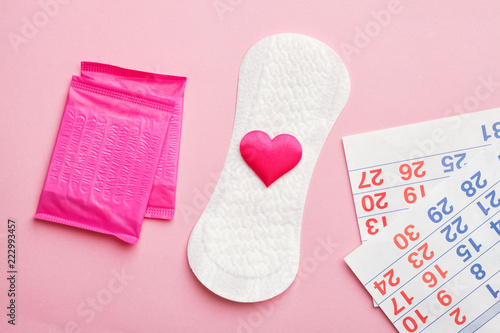sanitary pads and calendar on pink background, flat lay, top view