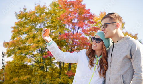 technology, people and season concept - smiling couple with smartphone taking selfie over autumn park background © Syda Productions