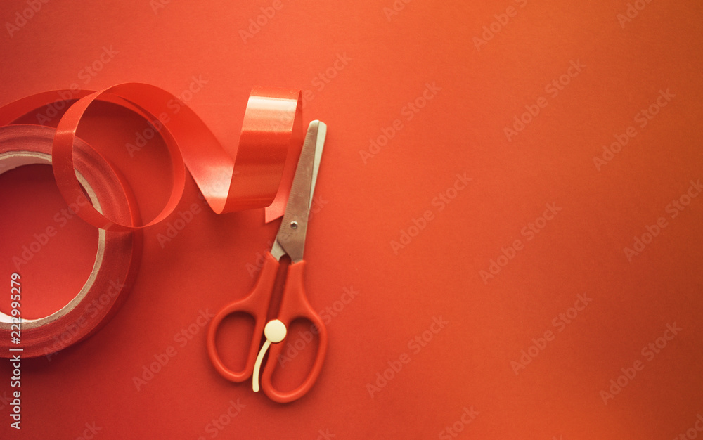 red ribbon and scissors on red background with copy space red ribbon and scissors on red background with copy space