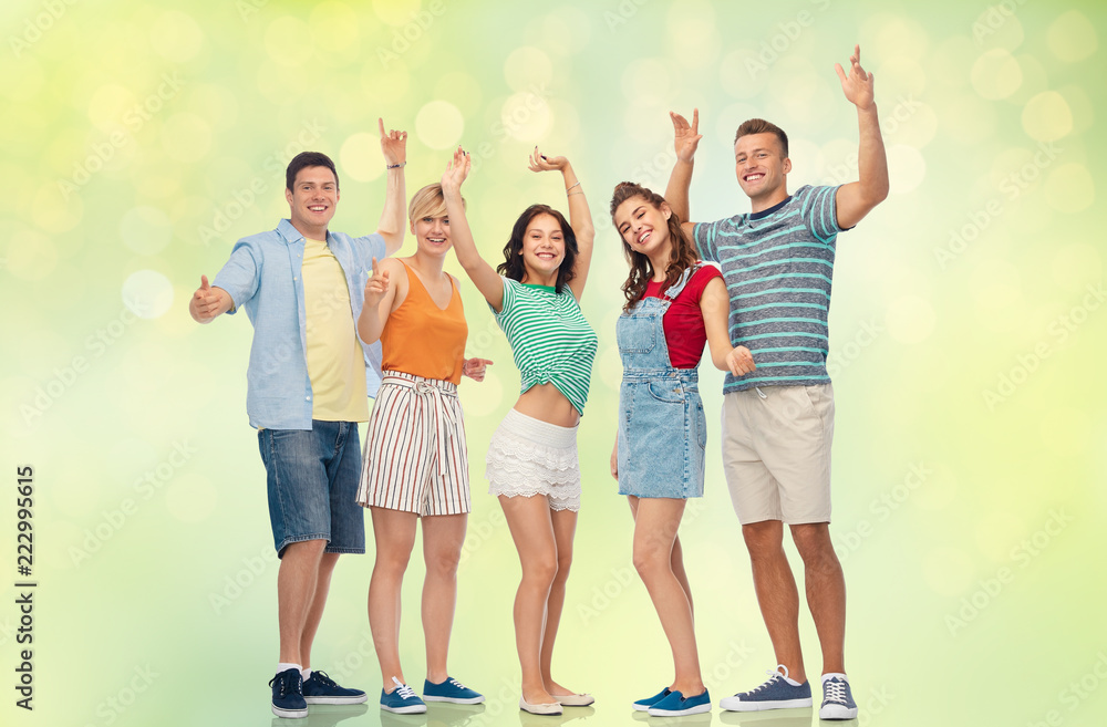Obraz premium friendship and people concept - group of happy smiling friends over festive lights on green background