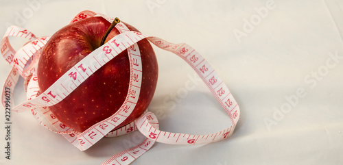 red apple with measurig tape, weigh loss concept photo