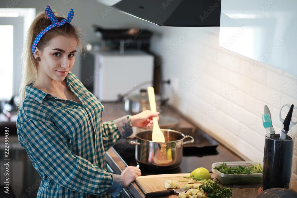 A cute young girl in the kitchen prepares food A cute young girl in the kitchen prepares food